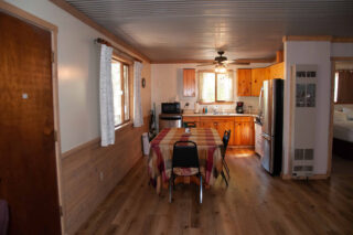 Cozy cabin kitchen and dining room with rustic charm, perfect for family gatherings and enjoying meals together.