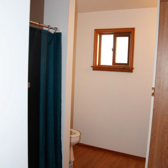Cozy restroom with shower, toilet and window for fresh air.